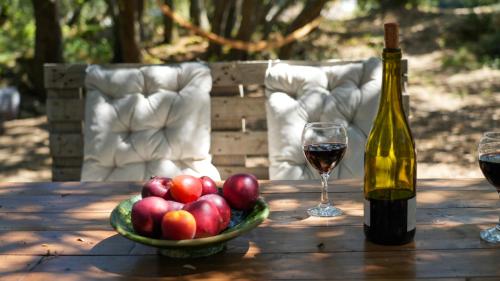 a bowl of apples and a glass of wine on a table at La cabane - Nature et Spa in Aurons