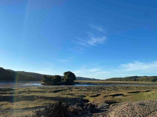 a view of a river with a rainbow in the distance at Cabaña Encanto del humedal Aituy in Aytuy