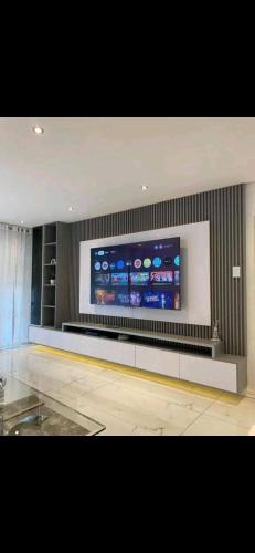 a room with a large flat screen tv on a wall at Tranquillity Cosy Lodge in Lilongwe