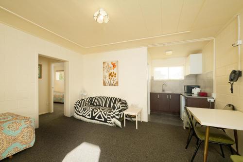 a living room with a zebra print couch and a kitchen at Blue Seas Motel in Kaikoura