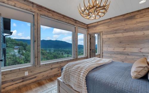 a bedroom with a bed and large windows at Hang Yer Hat in Sevierville