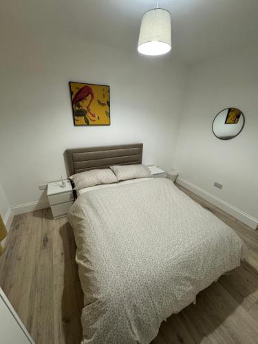 a bedroom with a bed in a white room at Absam Homes in London