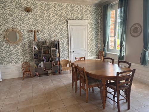 a dining room with a wooden table and chairs at Le Manoir de Conteville in Paluel