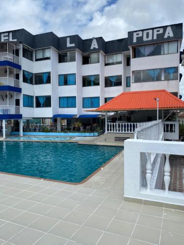 a hotel with a swimming pool in front of a building at Hotel la popa in Honda
