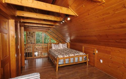 ein Schlafzimmer in einem Blockhaus mit einem Bett darin in der Unterkunft 4 Cubs Cove in Pigeon Forge