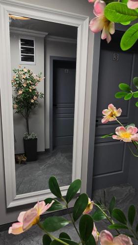 a mirror in a room with pink flowers at Novum Stay - Pensiune Centrala in Hunedoara in Hunedoara