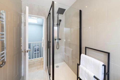 a bathroom with a shower and a glass shower stall at Oxford Escape - Stylish 3 Bedroom Holiday Home with free parking in Oxford
