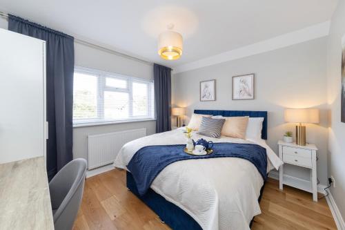 a bedroom with a bed with a blue and white bedspread at Oxford Escape - Stylish 3 Bedroom Holiday Home with free parking in Oxford
