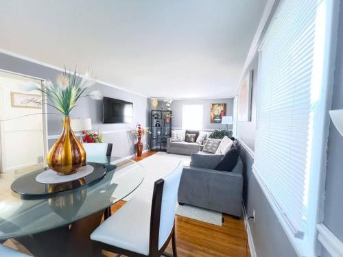 a living room with a vase on a glass table at Cozy 5 bedroom Home mins from RIT in Rochester