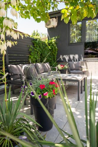 a patio with a bench and some plants and flowers at Apartments AMALFI Old Town FREE Parking in Sarajevo