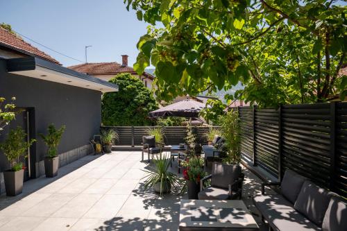 a patio with chairs and tables and an umbrella at Apartments AMALFI Old Town FREE Parking in Sarajevo