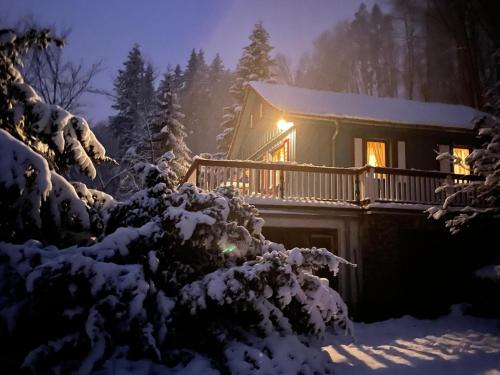 a house covered in snow at night with lights at Waldhaus im Erzgebirge in Augustusburg