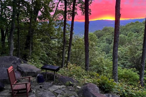a table and chairs sitting on a rock with a sunset at Timberwinds 1804 in Gatlinburg
