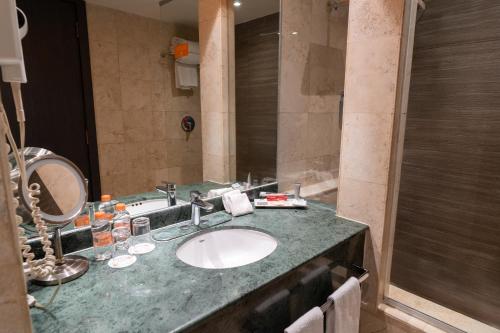 a bathroom with a sink and a mirror at Real Inn Tijuana by Camino Real Hoteles in Tijuana