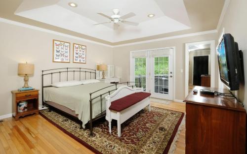 ein Schlafzimmer mit einem Bett und einem Flachbildfernseher in der Unterkunft Hen Wallow Creek Cottage in Cosby