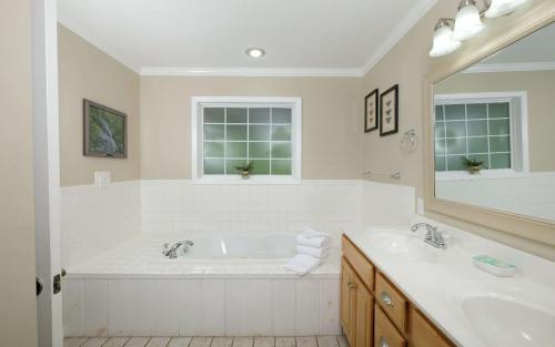 ein weißes Badezimmer mit zwei Waschbecken und einer großen Badewanne in der Unterkunft Hen Wallow Creek Cottage in Cosby