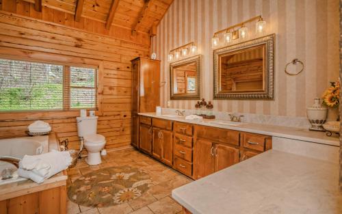 a bathroom with a toilet and a sink and a tub at Pop A Bear in Pittman Center