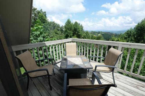a balcony with two chairs and a table on a deck at Holly Tree Cabin 936 in Gatlinburg