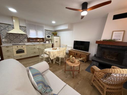 a living room with a couch and a table and a kitchen at Casa Rural MIÑONAS in Ibdes