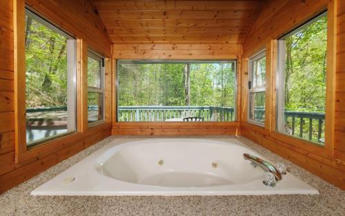 une baignoire dans une pièce avec des fenêtres dans l'établissement Ski Mountain Hideaway 1154, à Gatlinburg