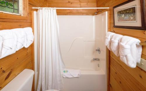 a bathroom with a white shower curtain and a tub at Smoky Getaway in Gatlinburg