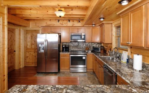 a kitchen with wooden cabinets and a stainless steel refrigerator at New Fox Lodge in Gatlinburg