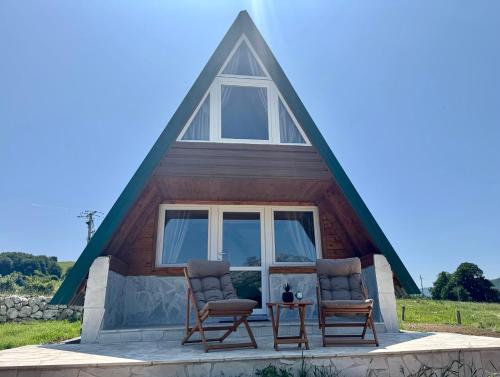 two chairs sitting on the front of a tiny house at Bungalovi Glava Bukovice in Žabljak