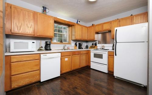 a kitchen with white appliances and wooden cabinets at Honey Bear Heaven in Gatlinburg