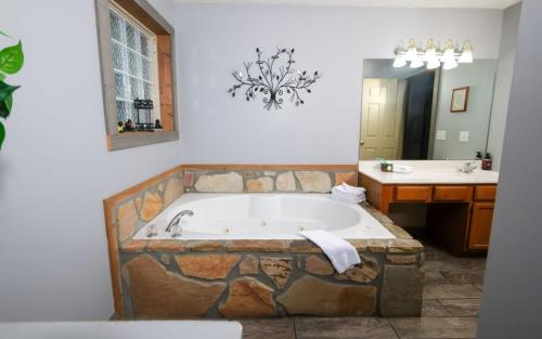a bathroom with a large bath tub and a sink at Honey Bear Heaven in Gatlinburg