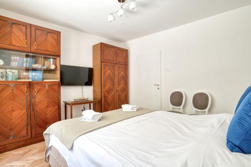 a bedroom with a large white bed and wooden cabinets at Apartment Seaside in Kotor