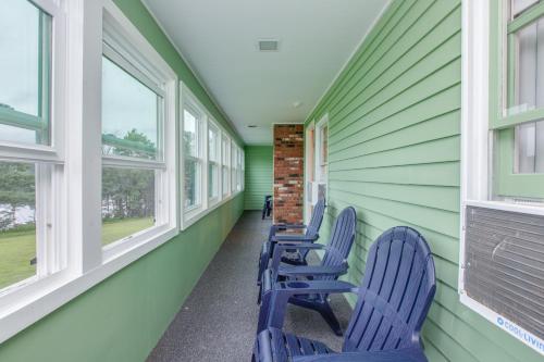 a row of blue chairs in a hallway with windows at Lake Shore Farm Inn in Northwood