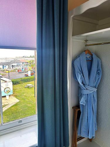 a blue curtain in a room with a window at Foxes Hotel in Minehead