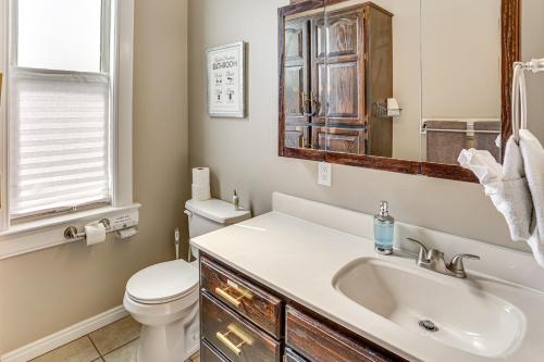 Un baño con lavabo, inodoro y espejo. en Charming Paris House about 1 half Mi to Canyon!, en Paris
