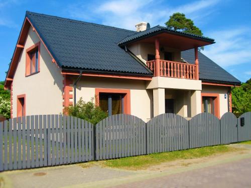 uma casa com uma cerca em frente em Romance em Ventspils