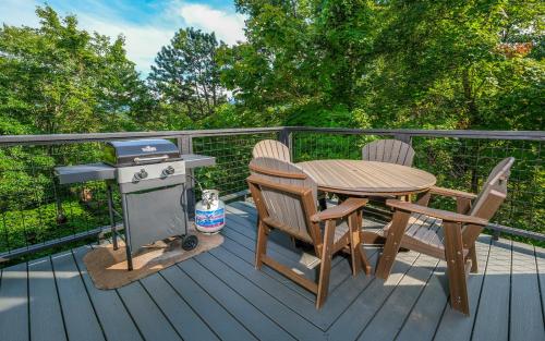 a grill and a table and chairs on a deck at Bear Hugs in Gatlinburg