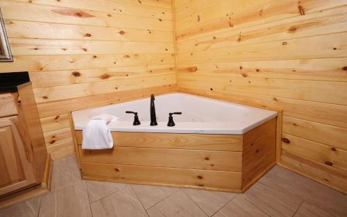 een badkamer met een bad in een houten muur bij Mountain Life in Sevierville