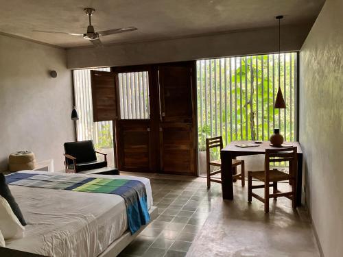 a bedroom with a bed and a desk and a table at Basico Pixoy Hotel in Valladolid
