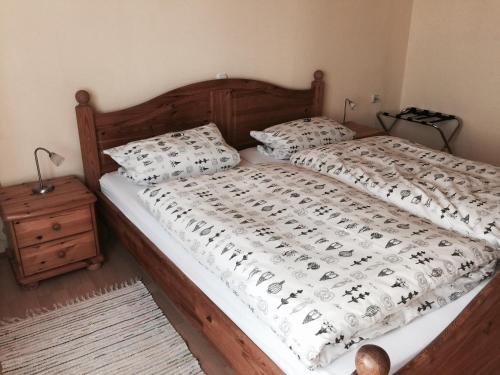 a bedroom with a bed with a wooden headboard and pillows at Pension Lindenhof in Limburg an der Lahn