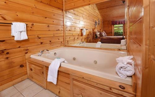 a bathroom with a tub in a log cabin at Bear Footin Heaven in Pigeon Forge