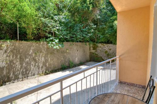 a balcony with a table and a fence and trees at Apartment Seaside in Kotor