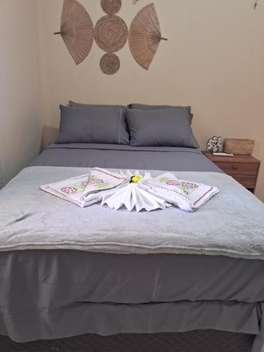 a bed with two robes on top of it at Casa vila costeira Guriú in Guriú