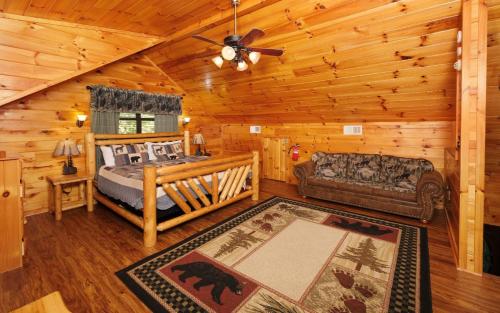 a bedroom with a bed and a couch in a cabin at Amazing Grace in Sevierville