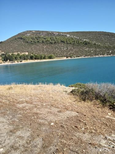 a view of a lake with a hill in the background at Alegria house with gardens near portoheli in Kranidi
