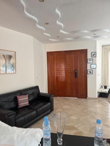 a living room with a couch and a table with water bottles at Villa Séphira in Fès