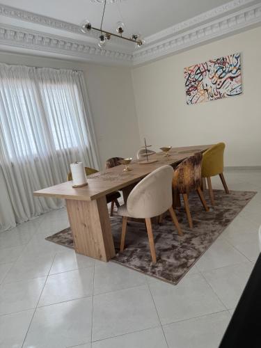 a dining room with a wooden table and chairs at Villa Séphira in Fès