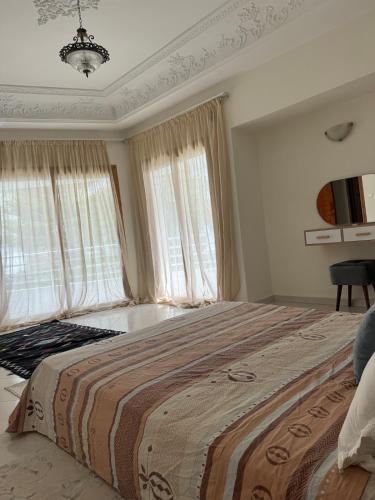 a bedroom with a large bed with windows at Villa Séphira in Fès