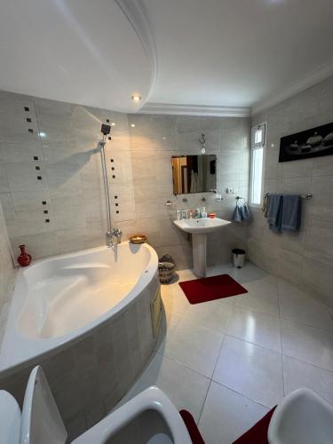 a white bathroom with a tub and a sink at Villa Séphira in Fès