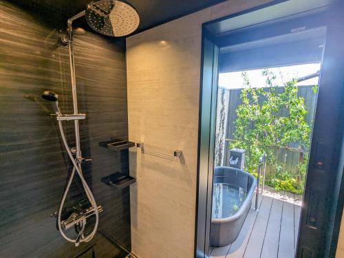 a bathroom with a shower and a glass door at Tabist Ryokufuen Kiyoharu in Takayama