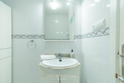 a white bathroom with a sink and a mirror at Mediterranean Bungalow in La Mata, Torrevieja in Torrevieja