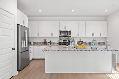 a kitchen with white cabinets and a large counter top at Spacious 5BR Getaway w Game Room & Modern Comfort in Fontana